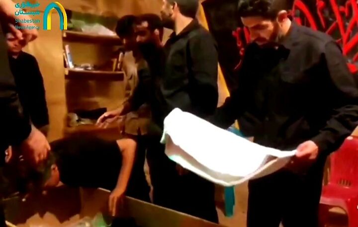 حضور شهید رحیم محمدی هنگام وداع با پیکر یکی از شهدای جنگ تحمیلی ۱۲ روزه