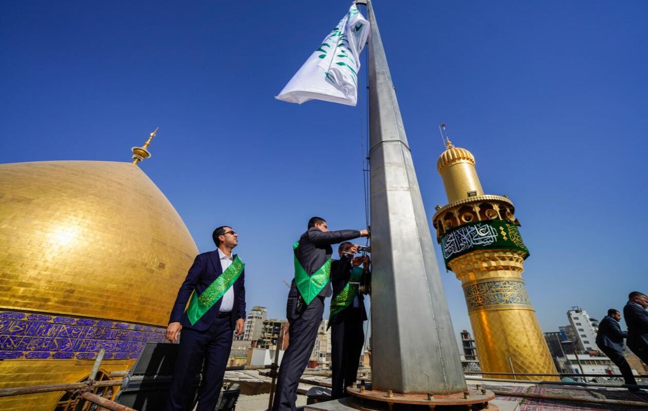 برافراشتن پرچم میلاد پیامبر اکرم(ص) بر فراز گنبد حرم امام علی(ع)+ عکس و فیلم
