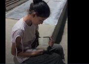 یک دختر فلسطینی در حال تلاوت قرآن مقابل سردخانه‌ای در غزه