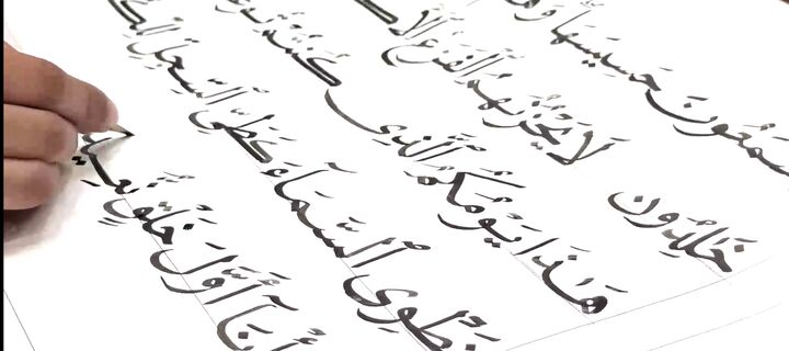 کتابت قرآن کریم توسط زائر پاکستانی در حرم مطهر رضوی