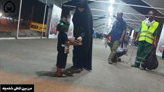 کودک زائر ابا عبدالله الحسین (ع) در مسیر زوار خدمات رسانی می کند